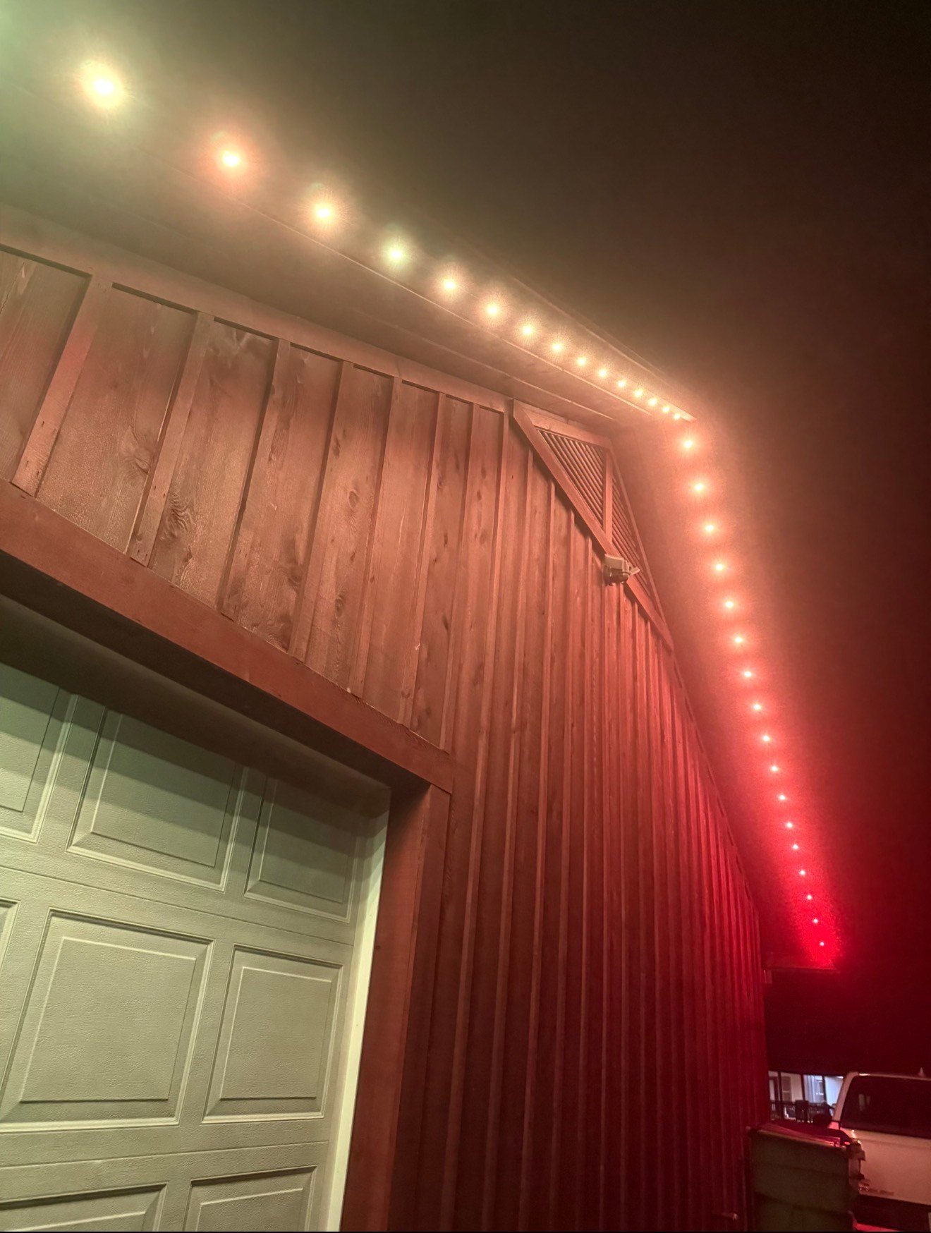 Close-up of warm white permanent LED trim lighting along a wood eave