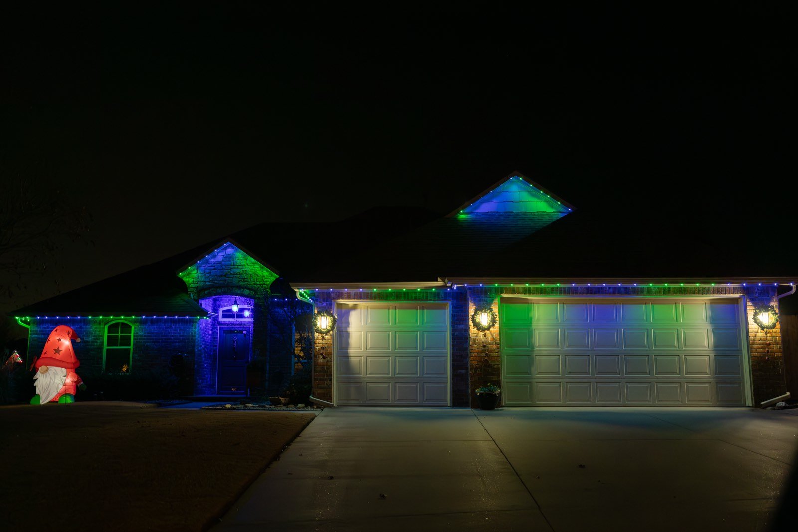 Permanent LED trim lighting glowing along a two-story Oklahoma City roofline at night