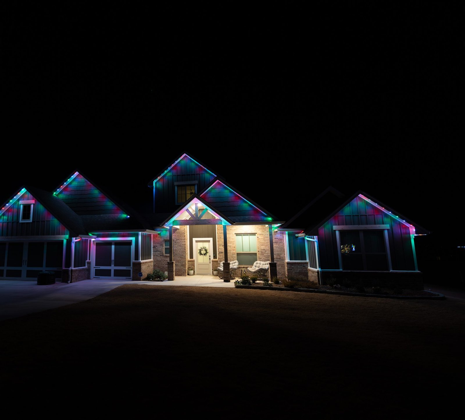 Single-story home with every gable and eave outlined in multicolor red, green, blue and magenta permanent LED roofline lighting