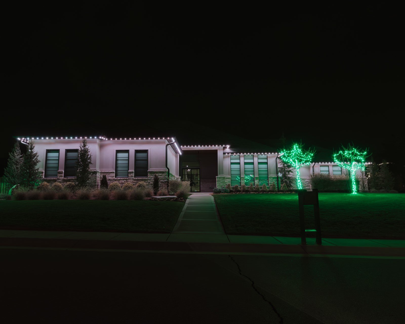 Bright white permanent security lighting across a home perimeter